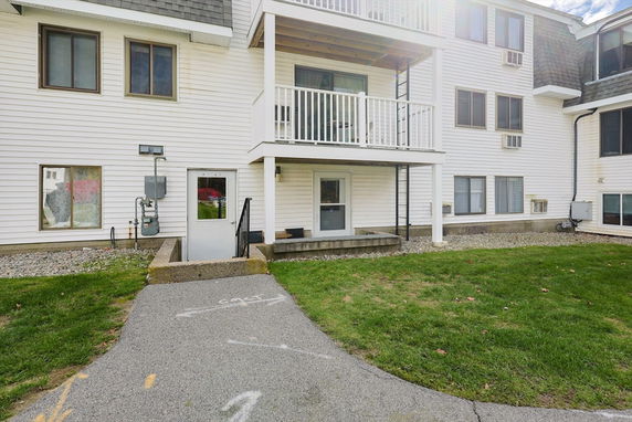 Front view of a multi-story building with a small balcony.