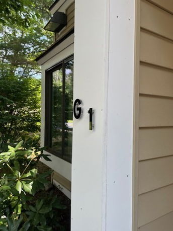 Corner view of a house with beige siding and large window.