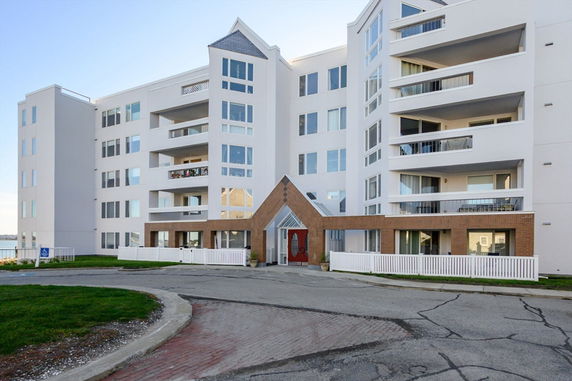 Front view of a multi-story building with balconies and a central entrance.