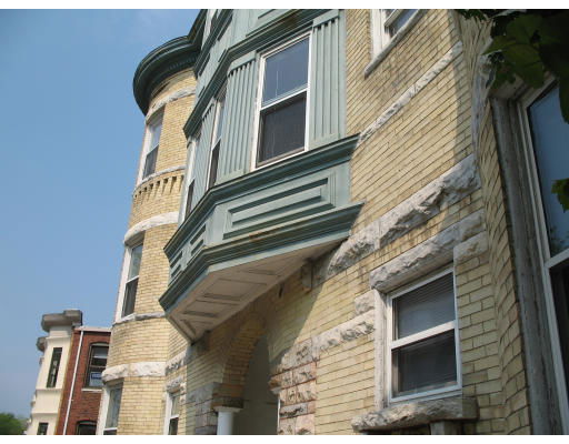 Front view of a multi-story brick building with detailed architectural accents.