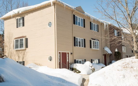 Front view of a multi-story house with snow-covered surroundings.