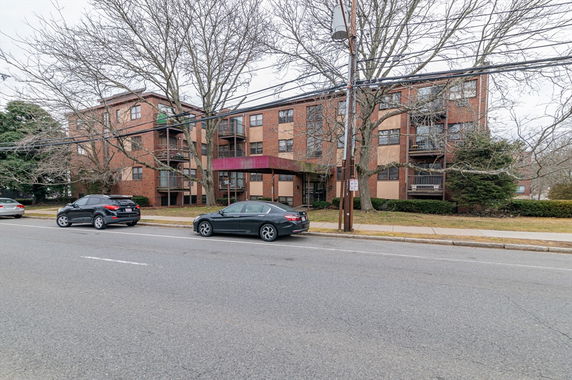 Front view of a multi-story apartment building with balconies.