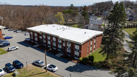 Front view of a rectangular two-story building with multiple windows and a flat roof.