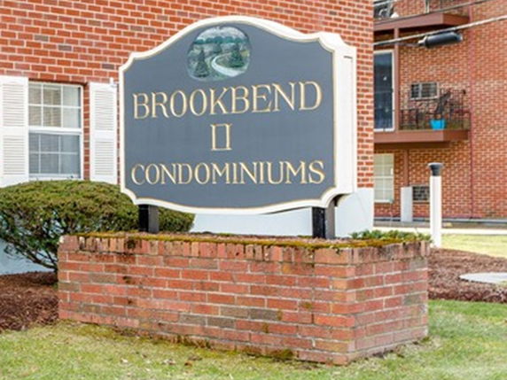 Front view of a red brick condominium building with white window shutters.