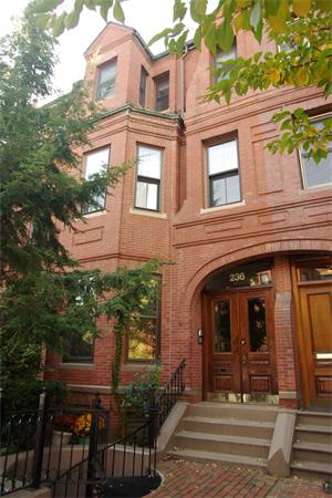 Front view of a multi-story brick building with ornate entryway.