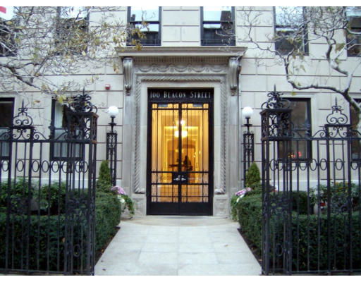 Front view of a building entrance with decorative iron gate and stone facade.