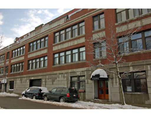 Front view of a multi-story brick building with large windows.