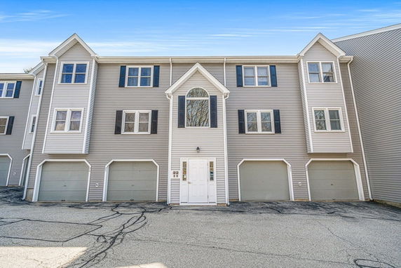 Front view of a multi-story residential building with garages.