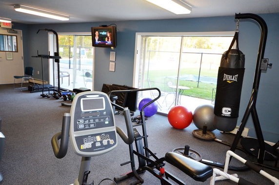 Indoor gym area with exercise equipment and a punching bag.