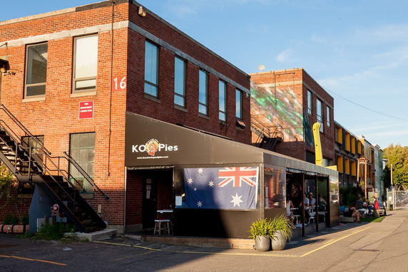 Front view of a brick building with outdoor seating area.