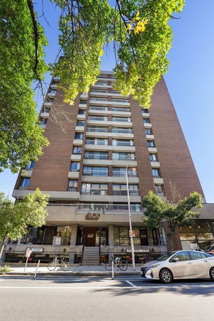 Front view of a multi-story apartment building with a brick facade.