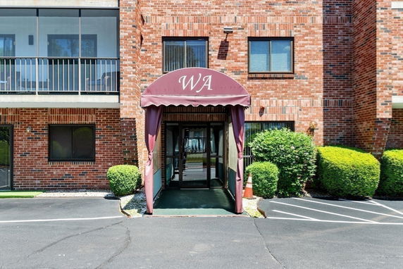 Front view of a brick building with an awning entrance.