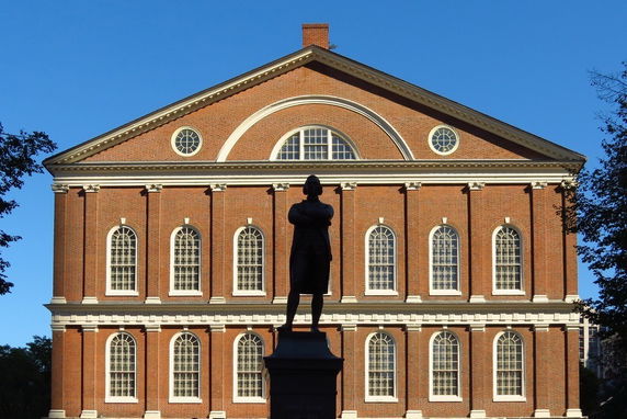 Front view of a historic red brick building with multiple arched windows.