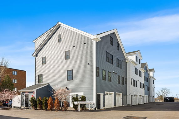 Front view of a multi-story residential building with multiple garages.