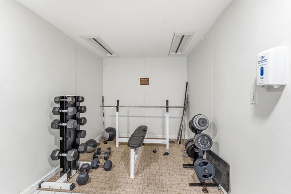 Indoor gym area with weights and exercise equipment.
