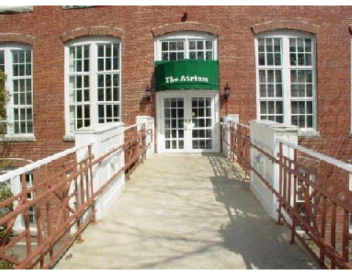 Front view of a brick building with large windows and an entrance canopy labeled 'The Atrium.'