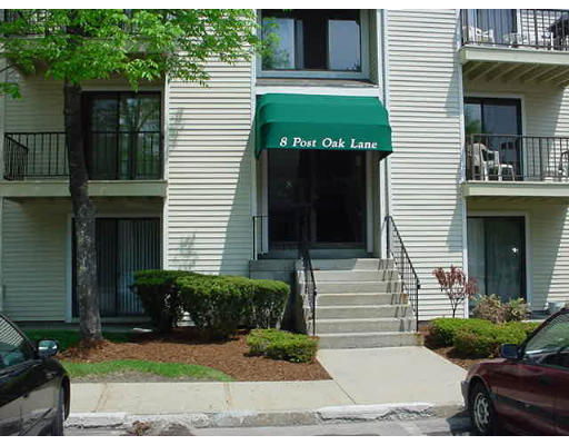 Front view of a multi-story apartment building with a green awning over the entrance.