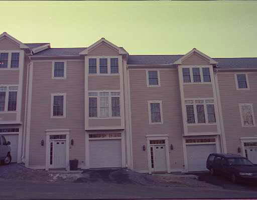 Front view of a multi-story townhouse with garages.