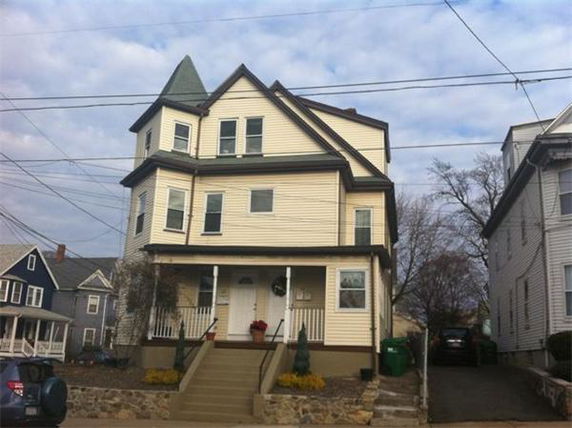 Front view of a multi-story house with a gabled roof and a small front porch.