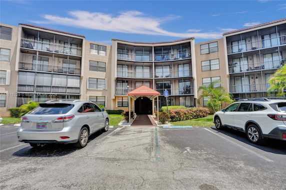 Front view of a four-story apartment building with a covered entrance.