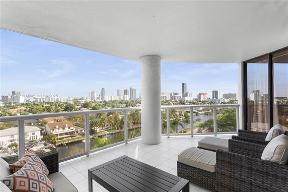 Balcony view overlooking a cityscape with high-rise buildings and waterway.