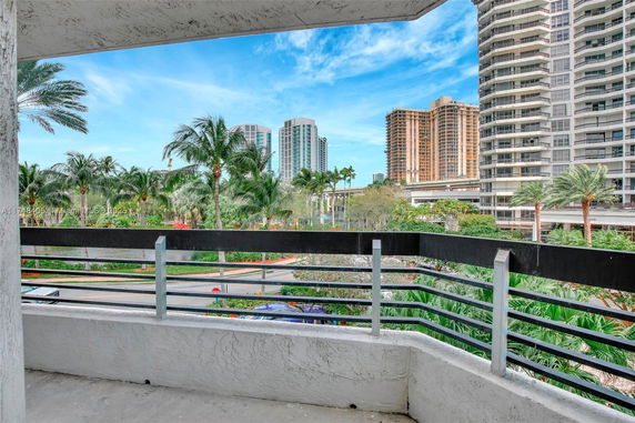 View from a balcony of high-rise buildings and palm trees.