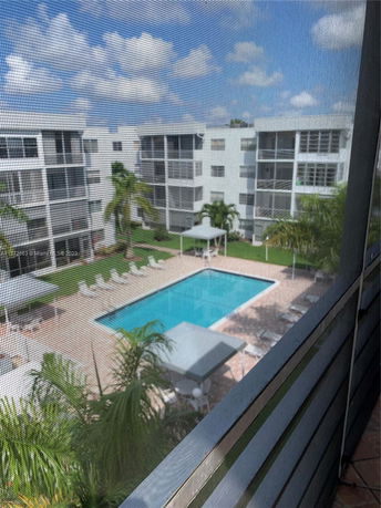View of a swimming pool surrounded by multi-story apartment buildings.