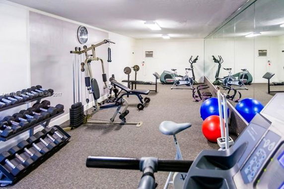 Indoor gym area with various exercise equipment including weights, exercise bikes, and a treadmill.