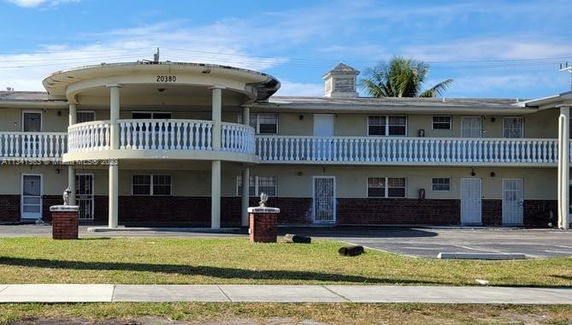 Front view of a two-story building with balconies and columns.