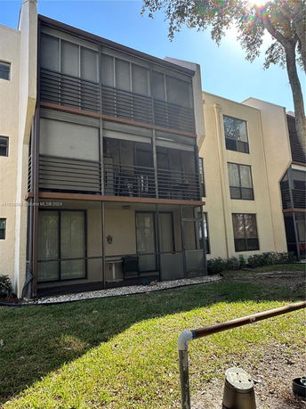 Front view of a multi-story apartment building with screened balconies.
