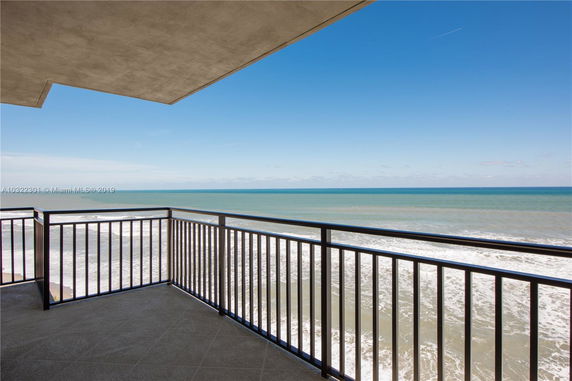 Ocean view from a balcony with metal railing.