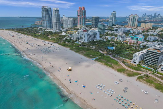 Aerial view of a beachside cityscape with high-rise buildings and a sandy beach.