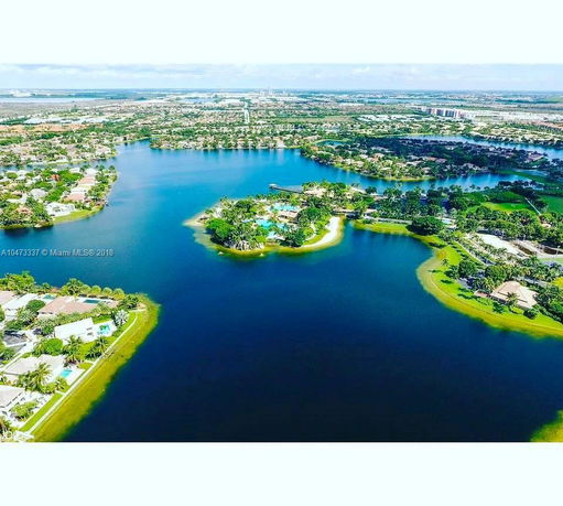 Aerial view of residential areas with many houses situated along a large body of water.