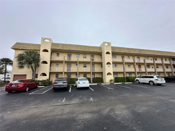 Front view of a three-story apartment building with balconies.