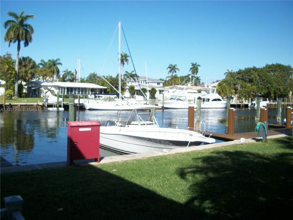 View of a marina with boats docked at a waterfront property.