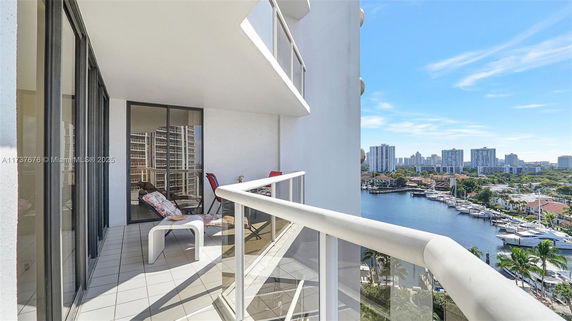 Balcony view with a panorama of water, boats, and city skyline.