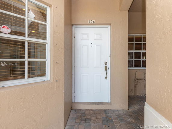 Front entrance of a house with a white door and beige exterior walls.