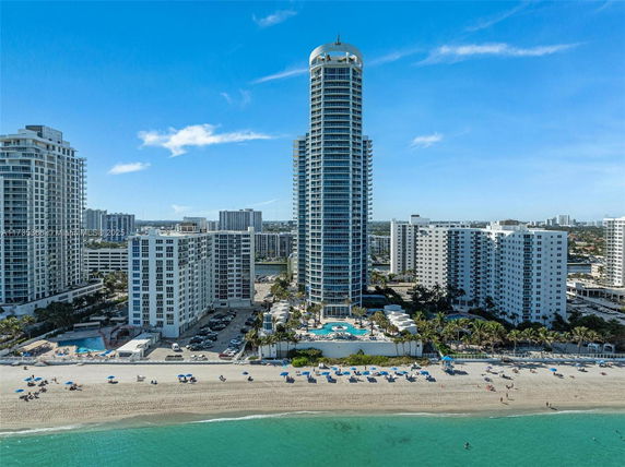 Front view of a tall, modern high-rise building near the beach.