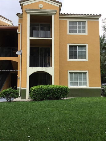 Front view of a three-story apartment building with balconies.