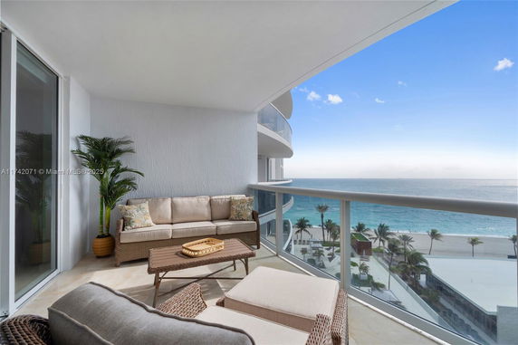 Balcony with outdoor seating overlooking the ocean.