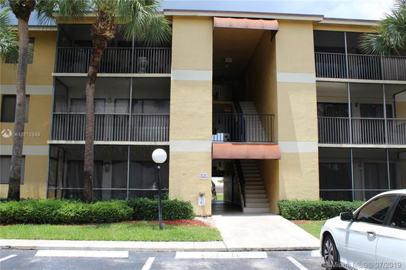 Front view of a three-story apartment building with an exterior staircase.