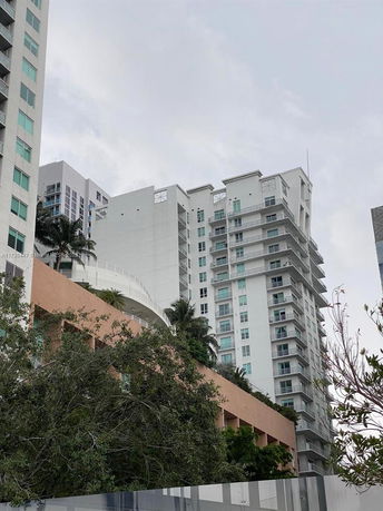Front view of a multi-story residential building with balconies and a modern design.