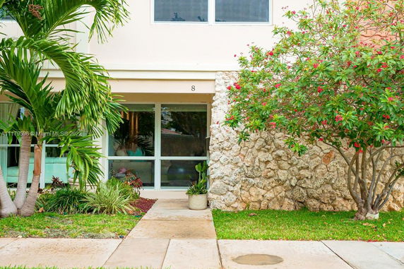 Front view of a house with large windows and stone facade.