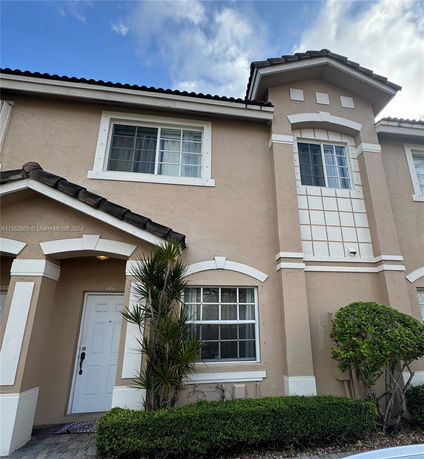Front view of a two-story house with architectural detailing around windows.