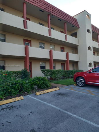 Exterior view of a multi-story building with an adjacent parking area.