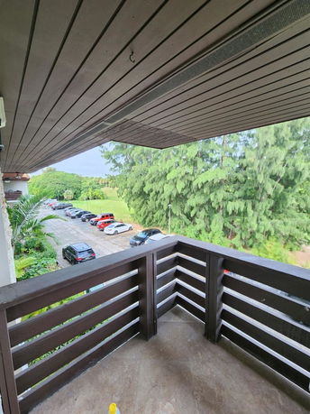 View from a balcony showing a parking area with multiple cars lined up.