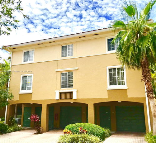 Front view of a multi-story house with three garage doors.