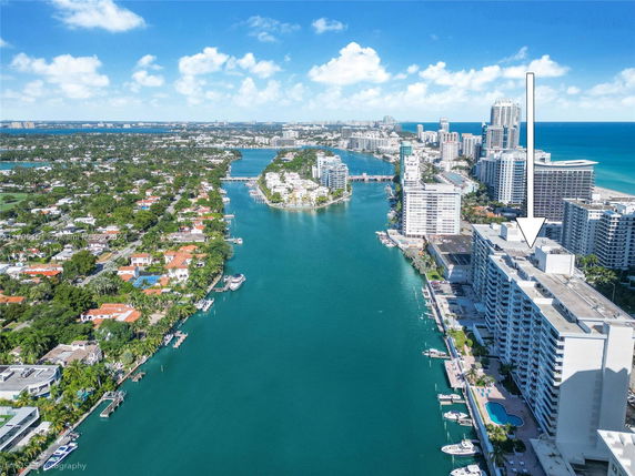 Aerial view of a coastal cityscape with buildings, waterways, and ocean.