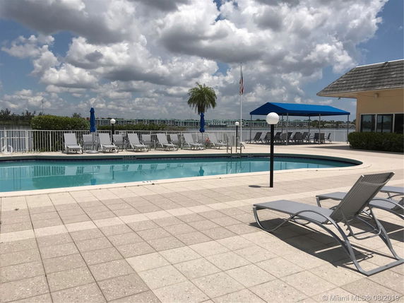 Outdoor pool area with lounge chairs and a view of the surrounding landscape.