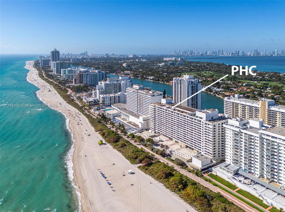 Aerial view of a beachfront city with tall buildings lined along the shore.